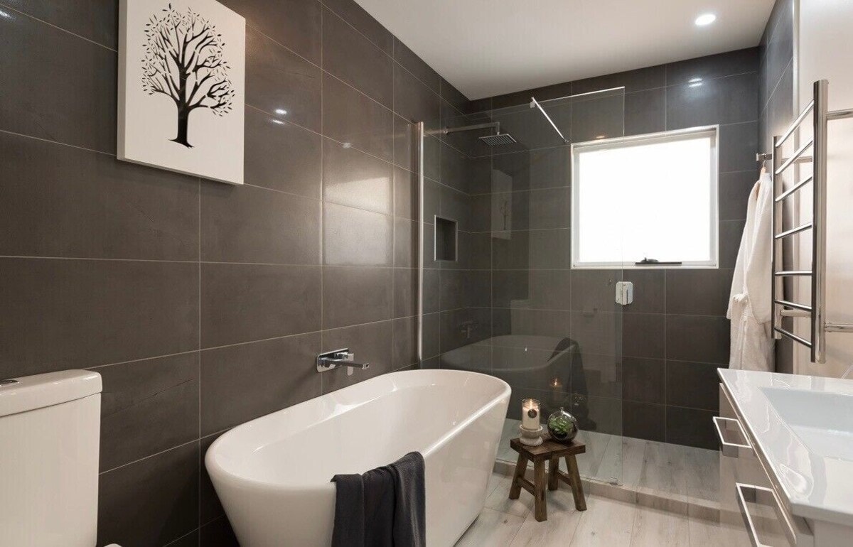 Luxurious bathroom with freestanding bath, rainfall shower and heated towel rail at Penguin Beach House