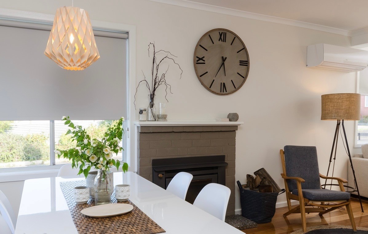 Open plan dining and living area with fireplace, pendant light, armchair and floor lamp